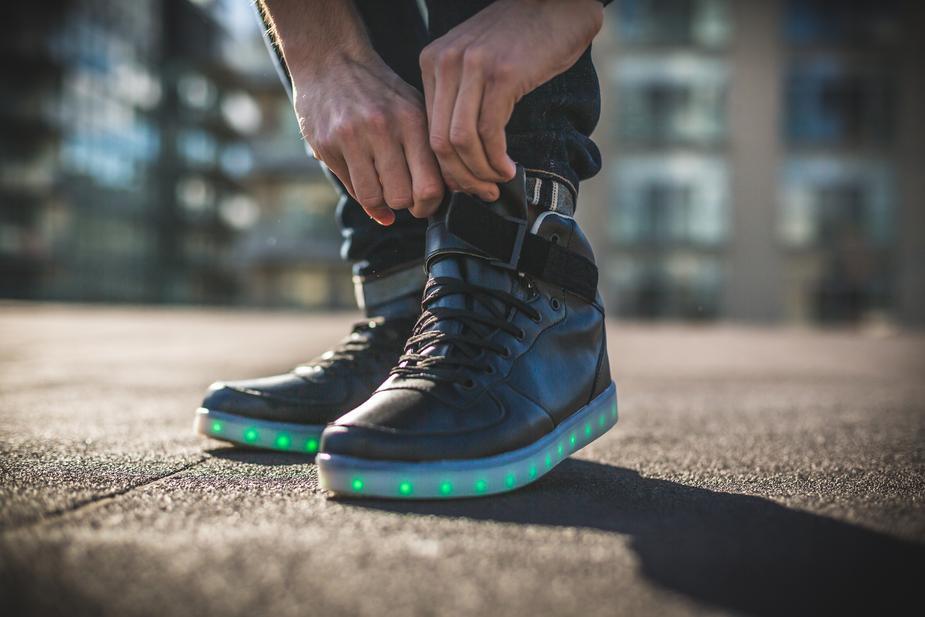 Man doing up his LED high top running shoes